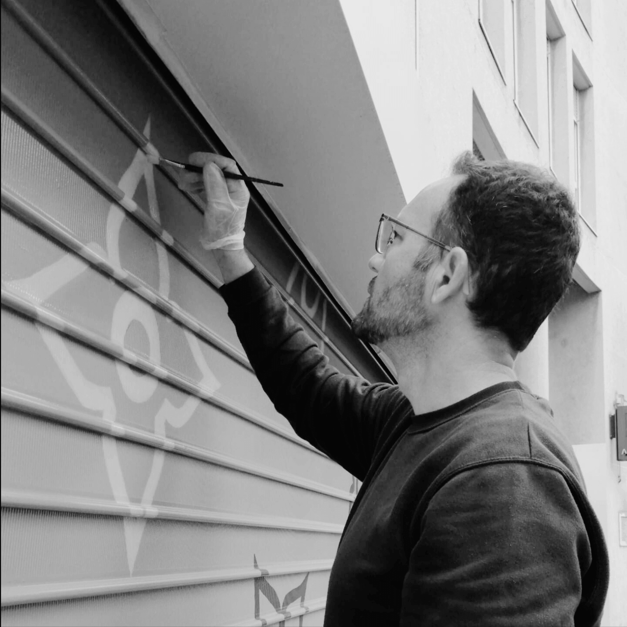 Yann Guillerd, artiste peintre ARTGY7, en train de peindre une fresque murale au pinceau Image